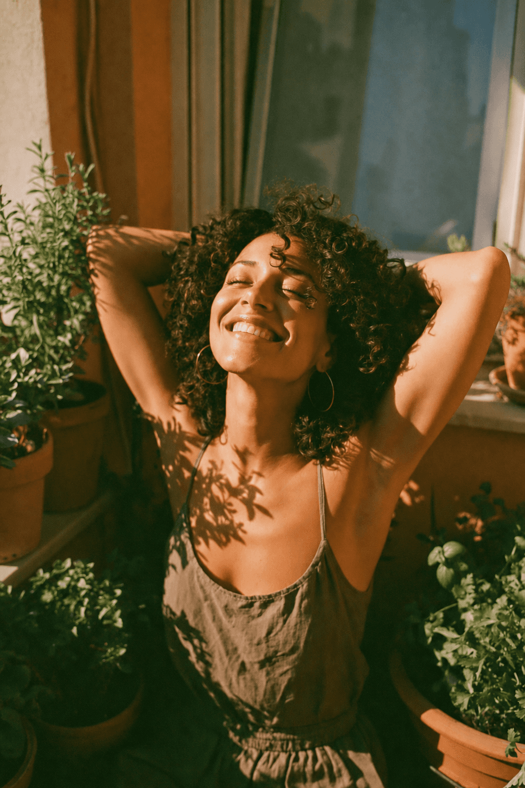 Teledris patient stretching joyfully on a sunlit balcony with potted herbs